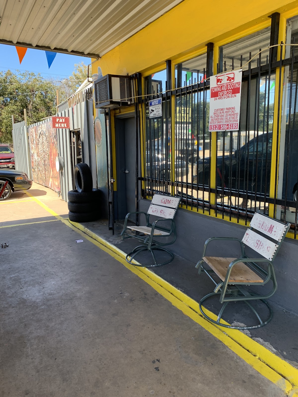 Side entrance of Leal's Tire Shop with stacked tires and pay-here sign